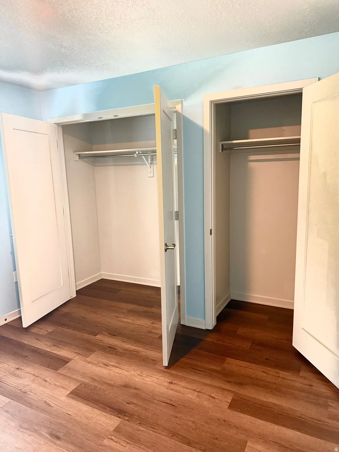 Dual closets featuring white shaker-style doors and integrated shelving with hanging rods