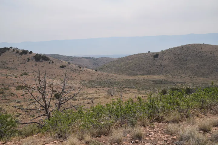 Expansive landscape featuring rolling hills and distant mountains