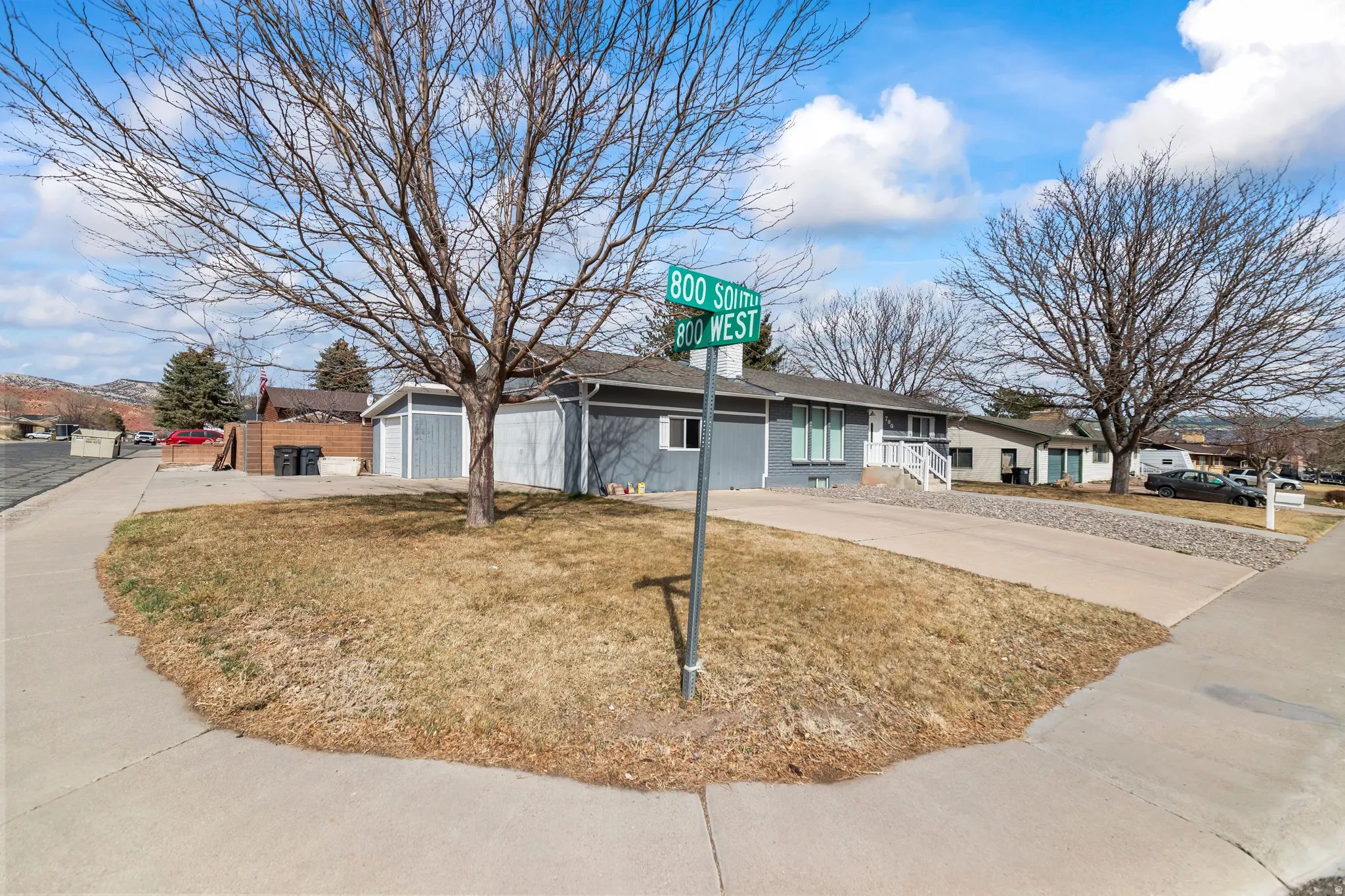 Ranch-style residence featuring a gray exterior with white trim, a two-car garage, and a concrete driveway