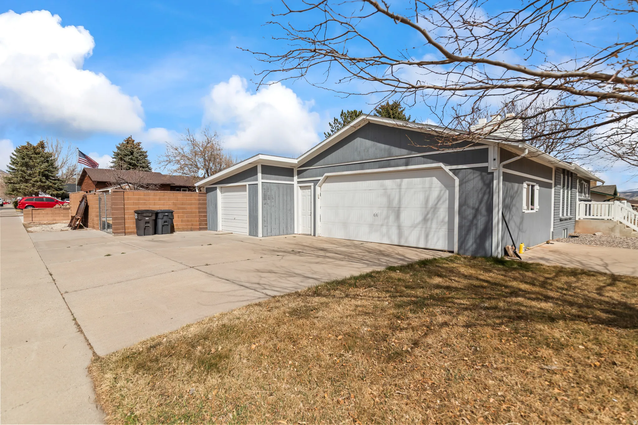 Multi-car garage with white garage doors and gray siding