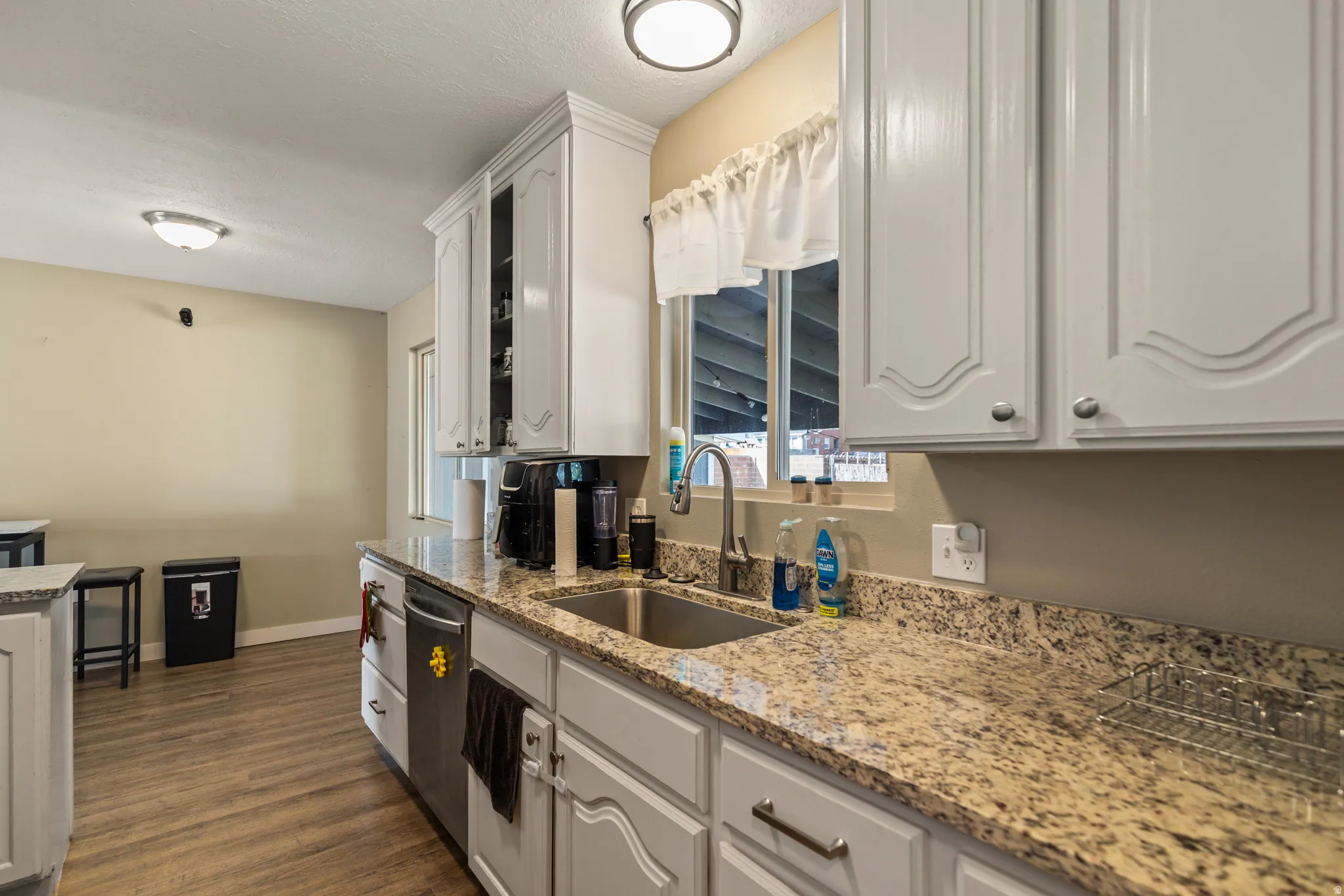 Kitchen featuring light-toned cabinetry with decorative paneling and stainless hardware