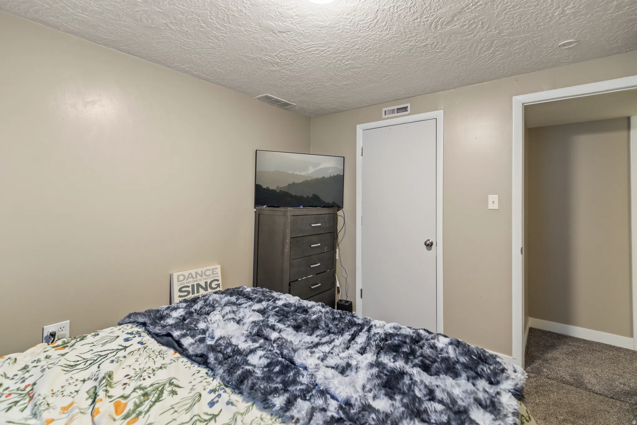 Neutral-toned walls complement a textured ceiling and light-colored trim