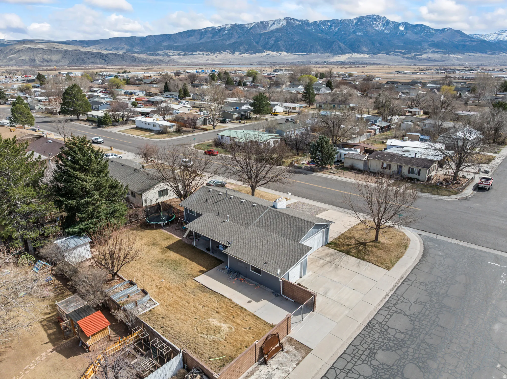 Expansive residential property featuring a gray exterior, attached garage, and a paved driveway