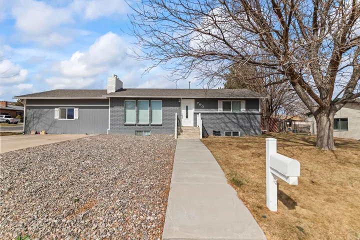 Split-level residence featuring a gray exterior with brick and siding elements