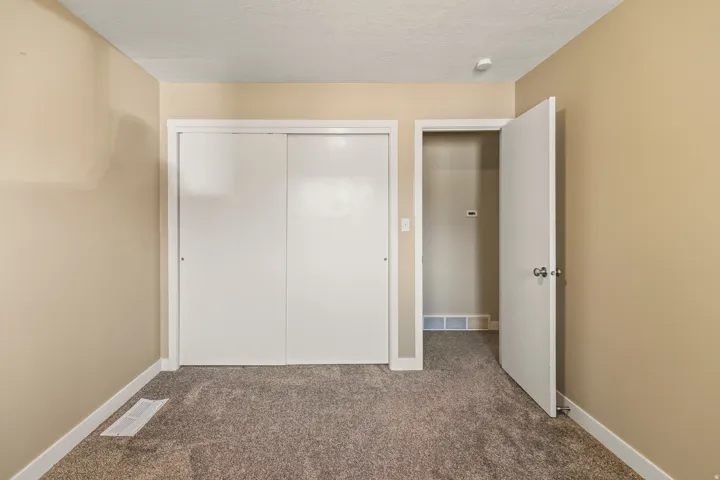 Room featuring neutral-toned walls and plush gray carpeting