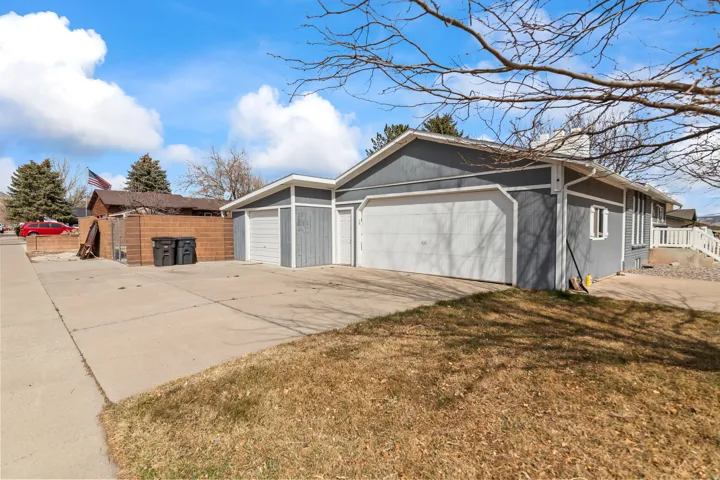 Multi-car garage with white garage doors and gray siding
