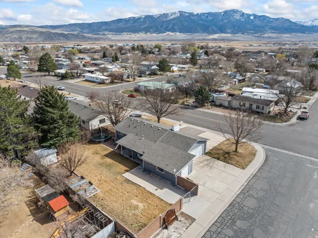 Expansive residential property featuring a gray exterior, attached garage, and a paved driveway