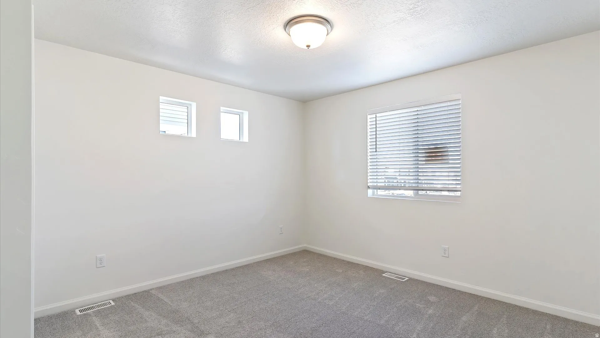 Neutral-toned room with plush gray carpeting and white painted walls