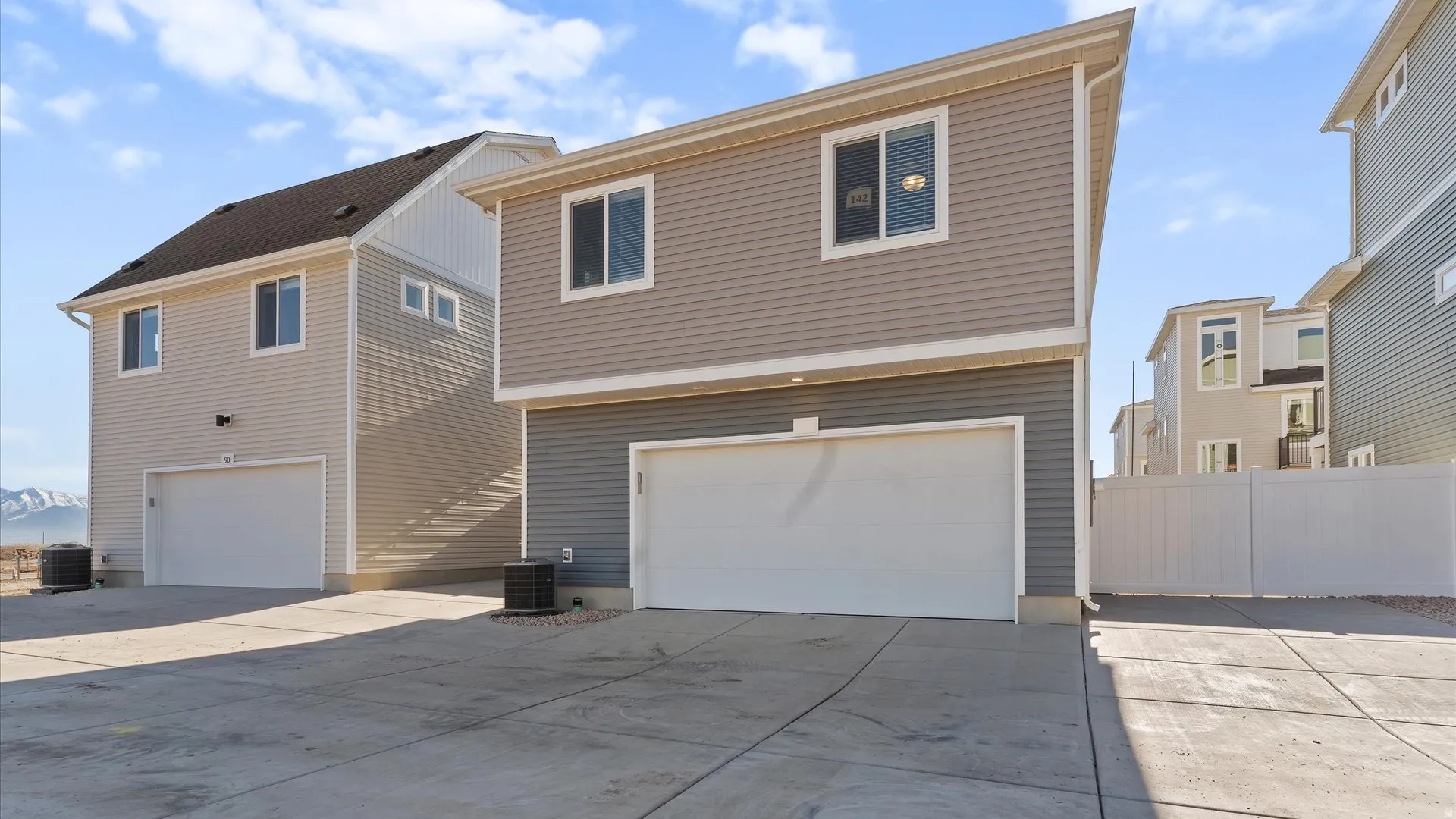 Modern two-story residence featuring a two-tone exterior with light gray siding on the upper level and dark gray siding on the lower level