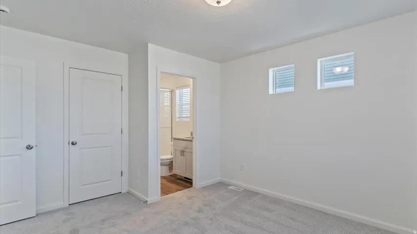 Neutral color palette throughout featuring light gray carpeting, white walls, and white trim