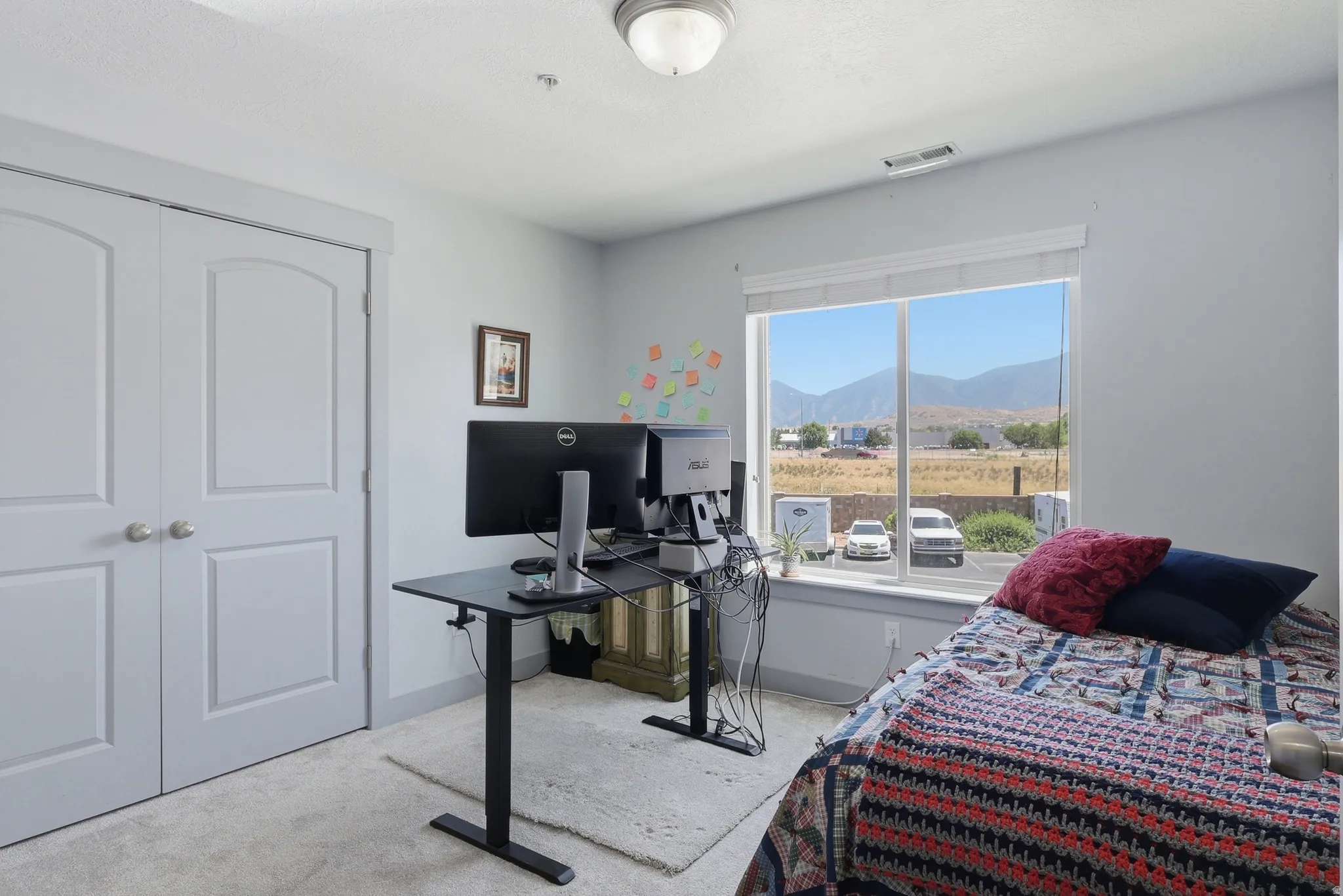 Room featuring a large window, soft carpet flooring, and light gray walls