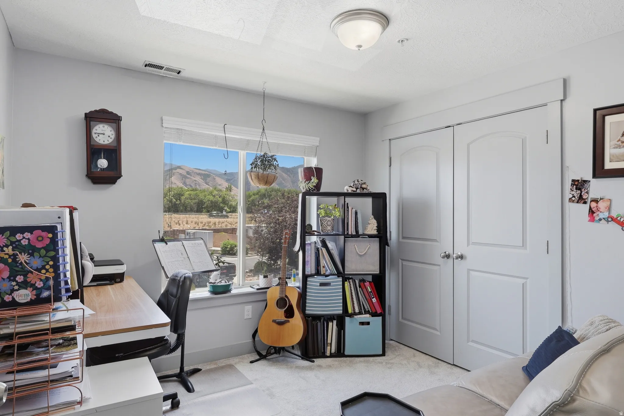 Interior room featuring a large window with mountain scenery, light gray walls, white trim, and a ceiling-mounted light fixture