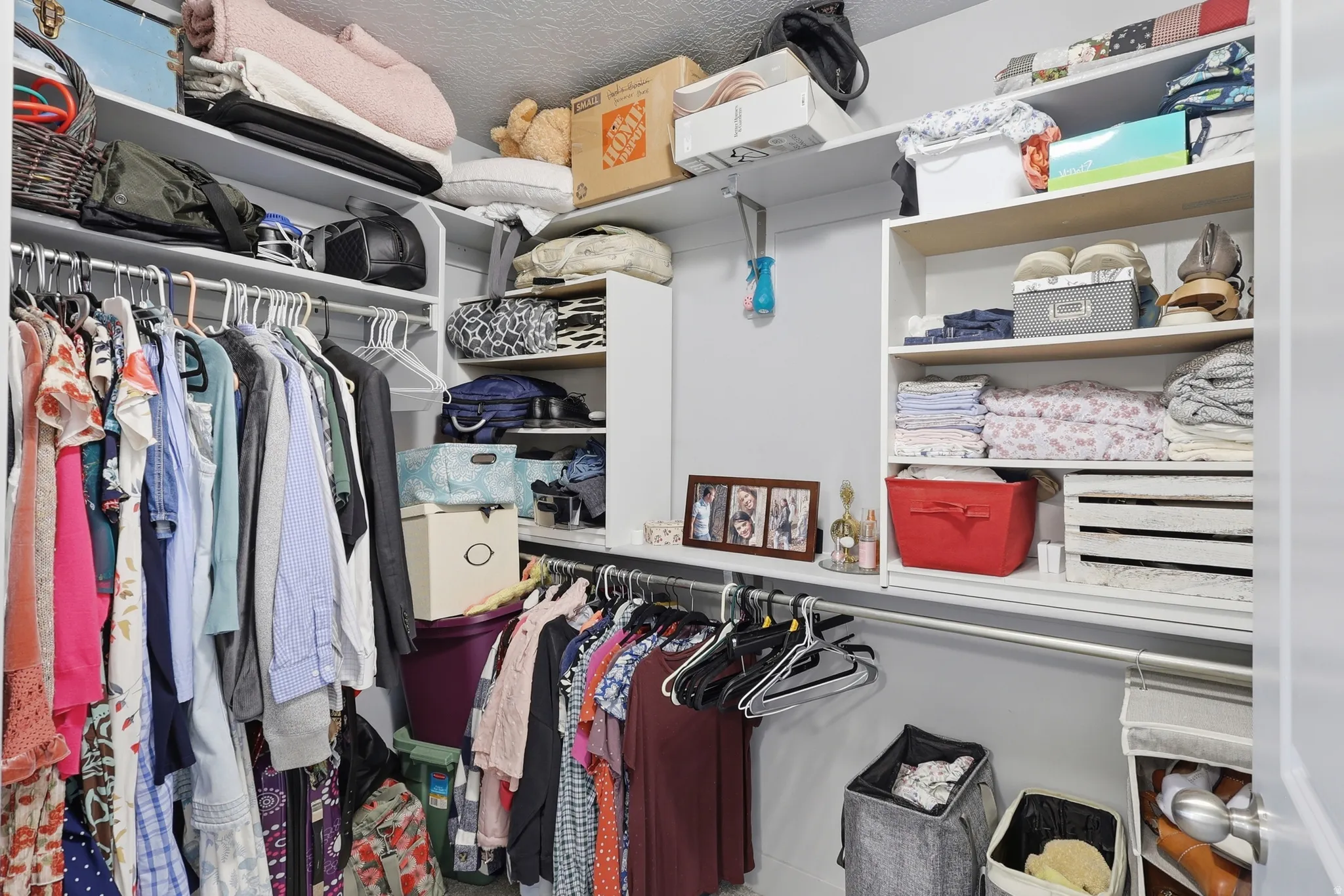 Walk-in closet featuring built-in shelving, multiple hanging rods, and ample storage space
