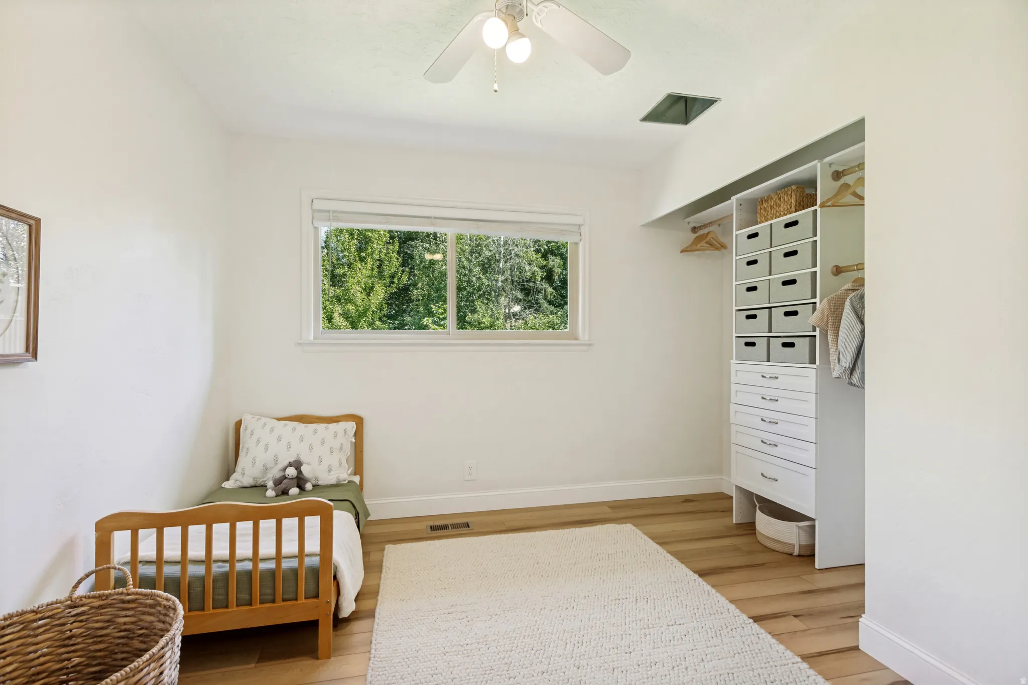 Room featuring a built-in closet organization system with shelving and drawers