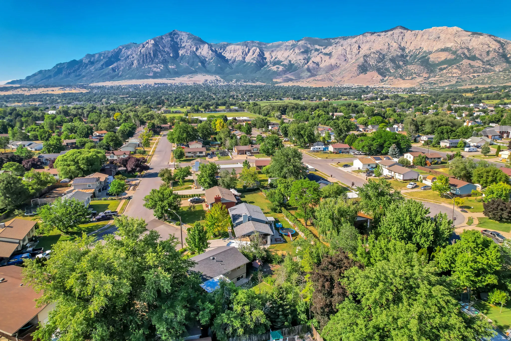 Expansive mountain range backdrop framing a residential area with mature trees and established streets