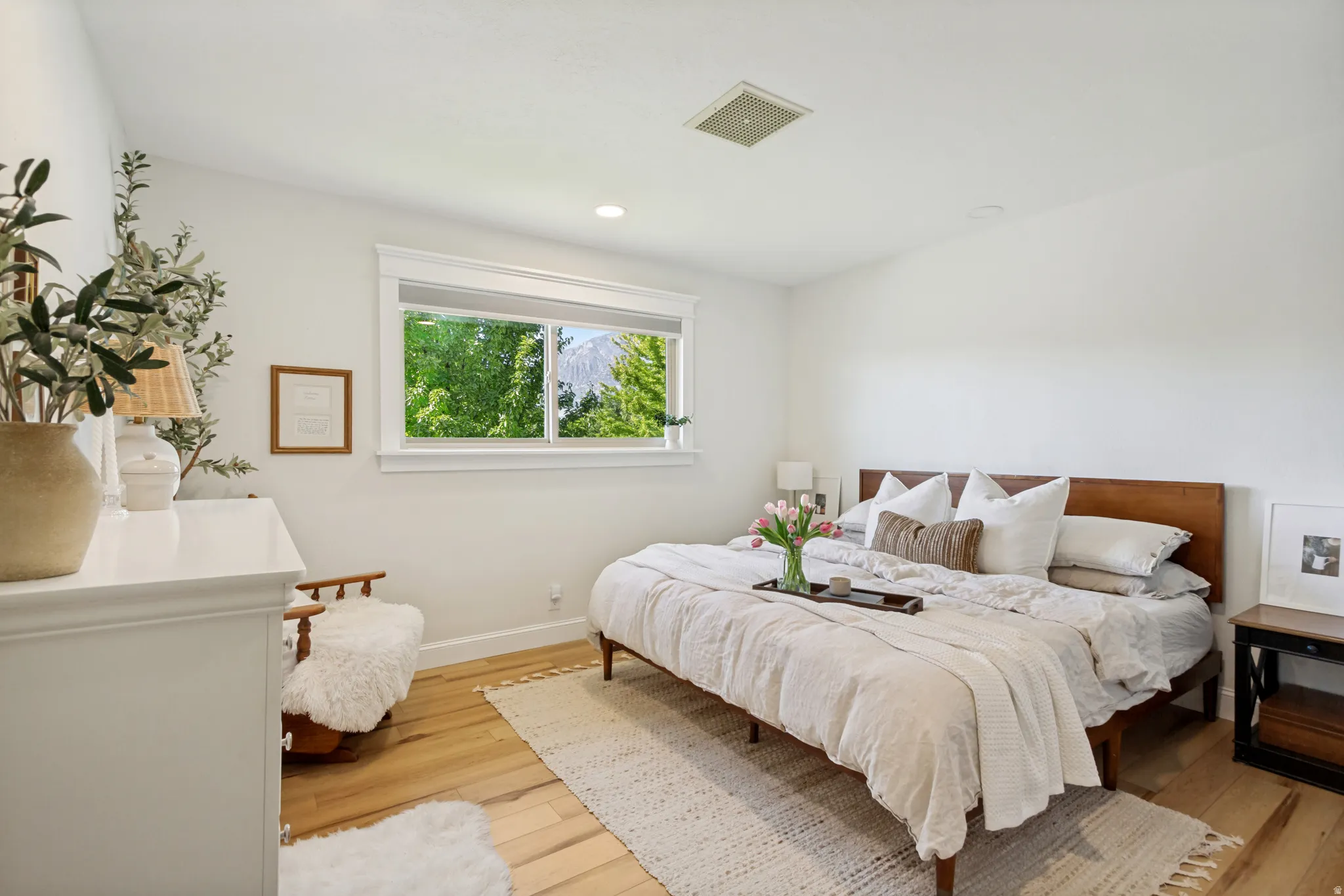 Bright room with wood-finish flooring, white walls, and recessed lighting