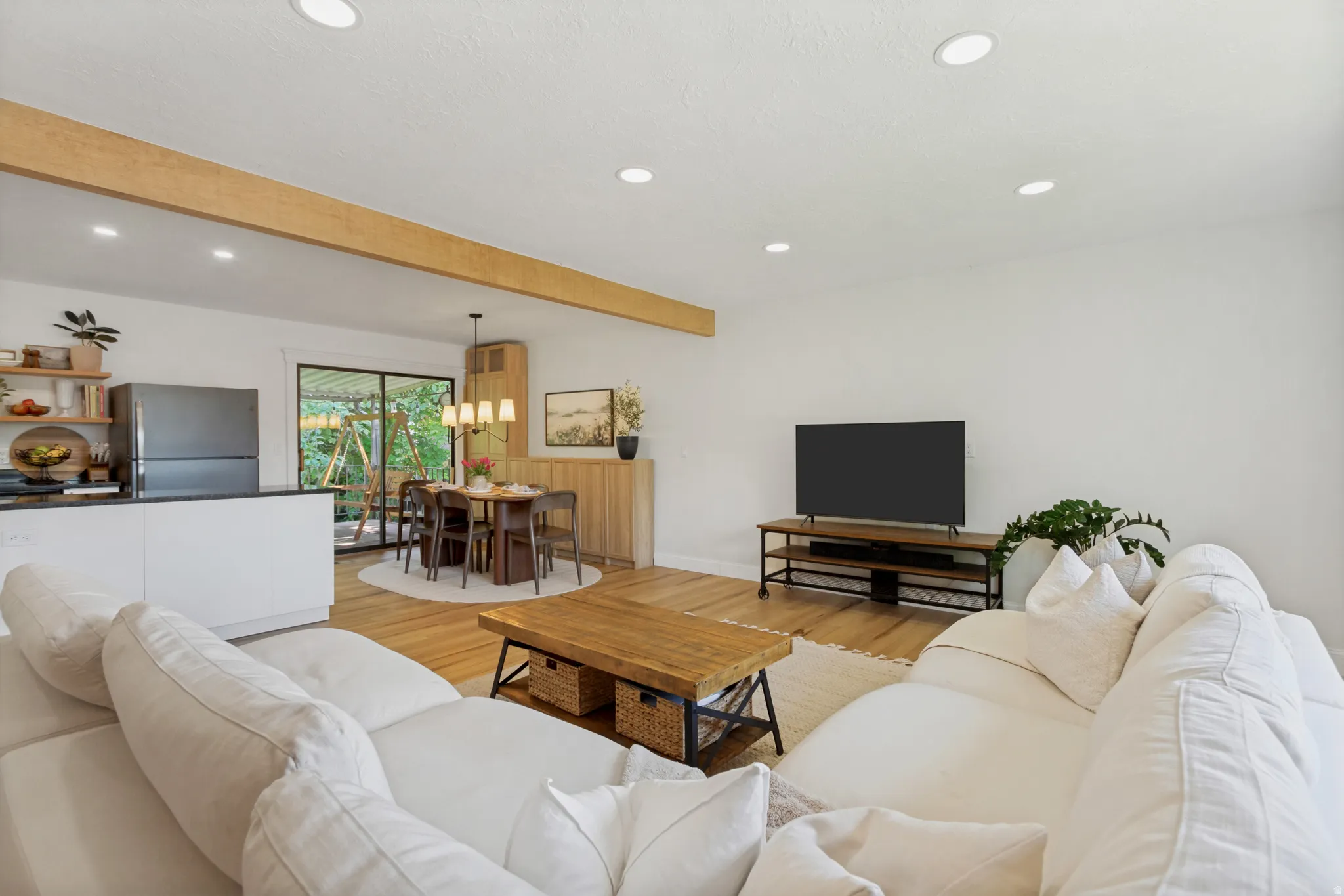 Open-concept living area featuring light wood-finish flooring and recessed lighting