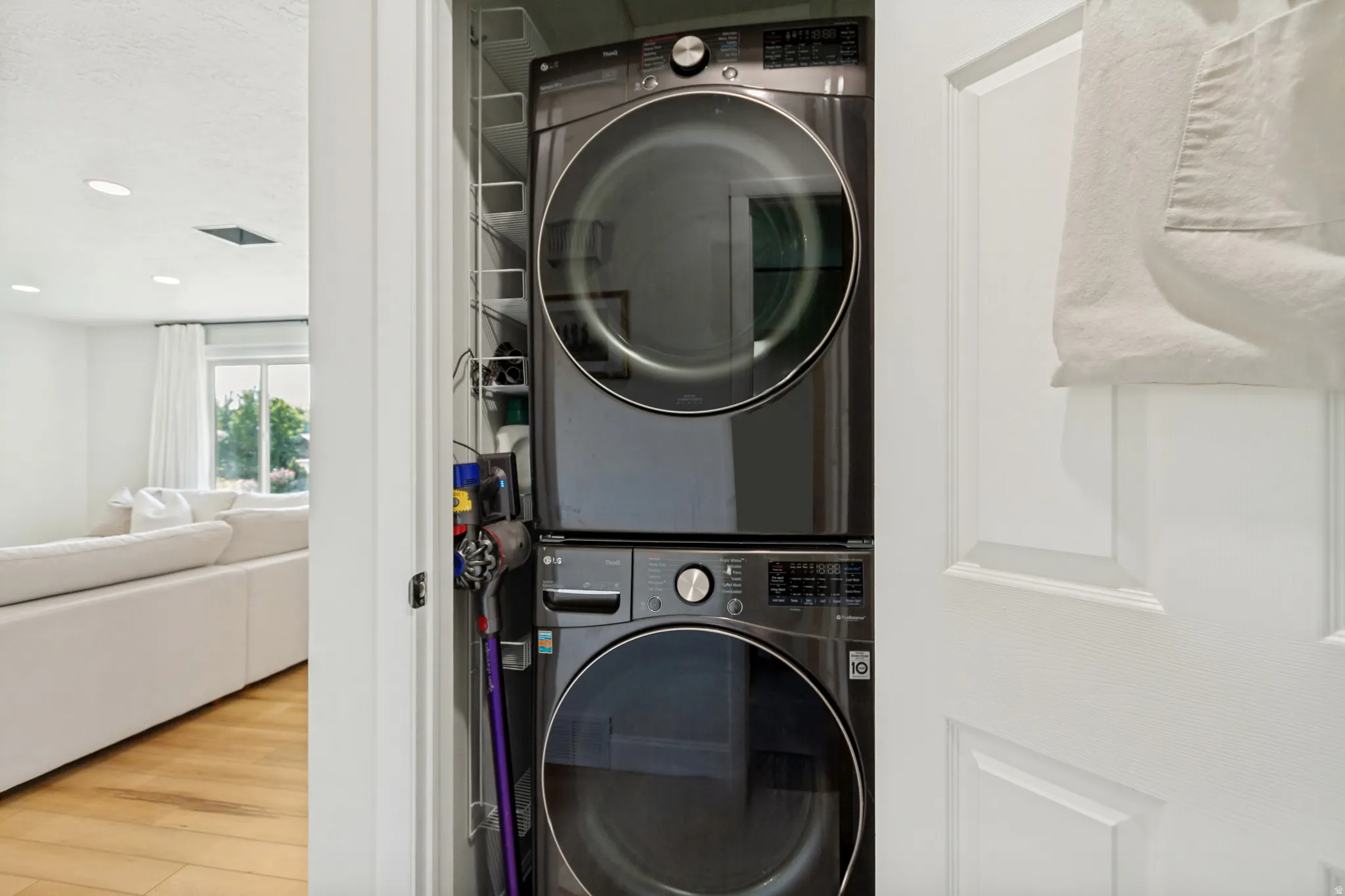 Dedicated laundry closet featuring a stacked front-load washer and dryer