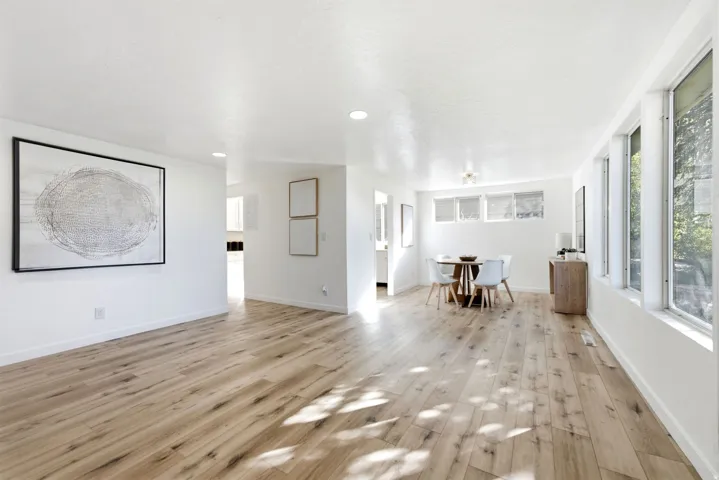 Expansive interior with wood-finish flooring, recessed lighting, and multiple large windows