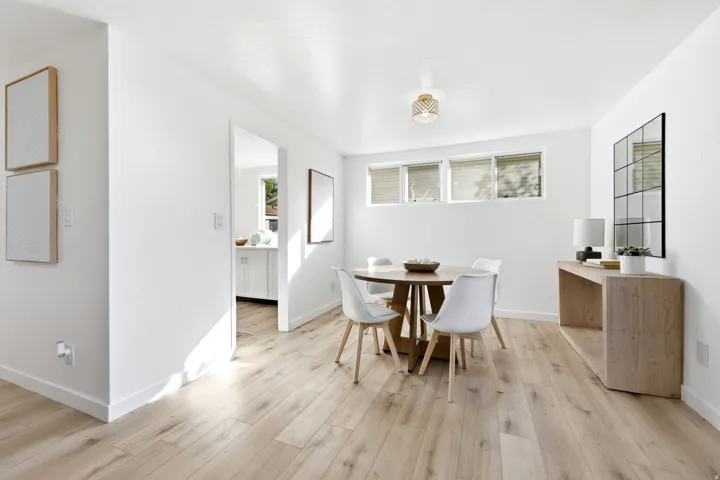 Light wood-finish flooring throughout, white walls, and a recessed ceiling light fixture