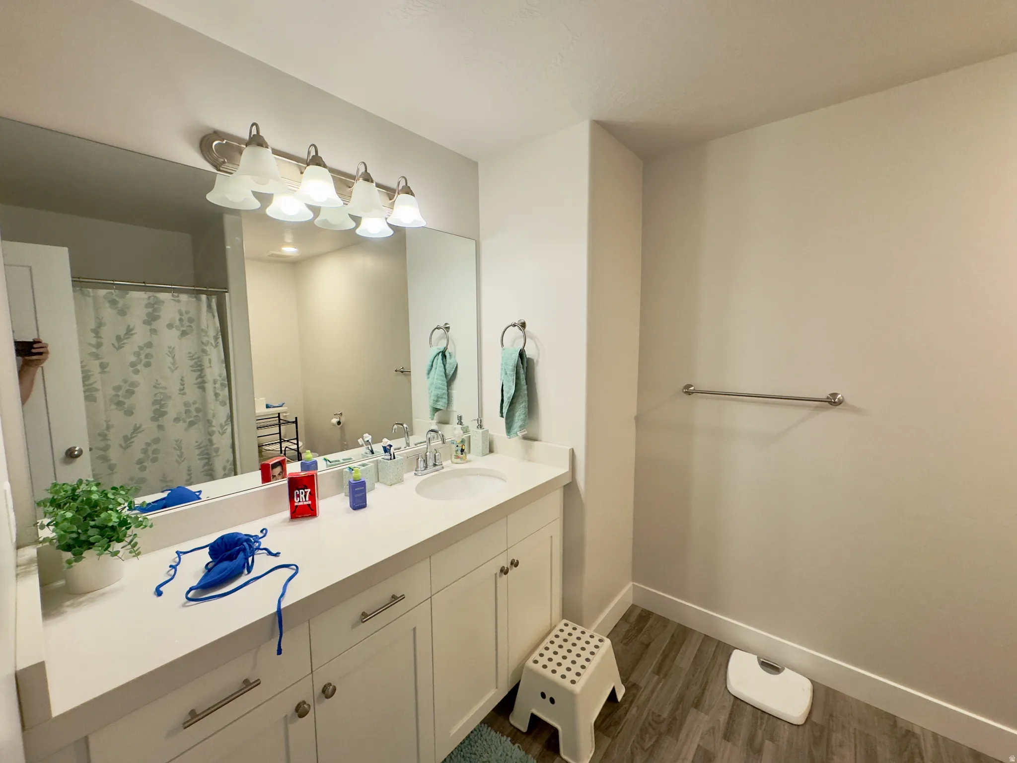 Bathroom featuring a wide vanity with an integrated sink, white cabinetry, and brushed nickel hardware