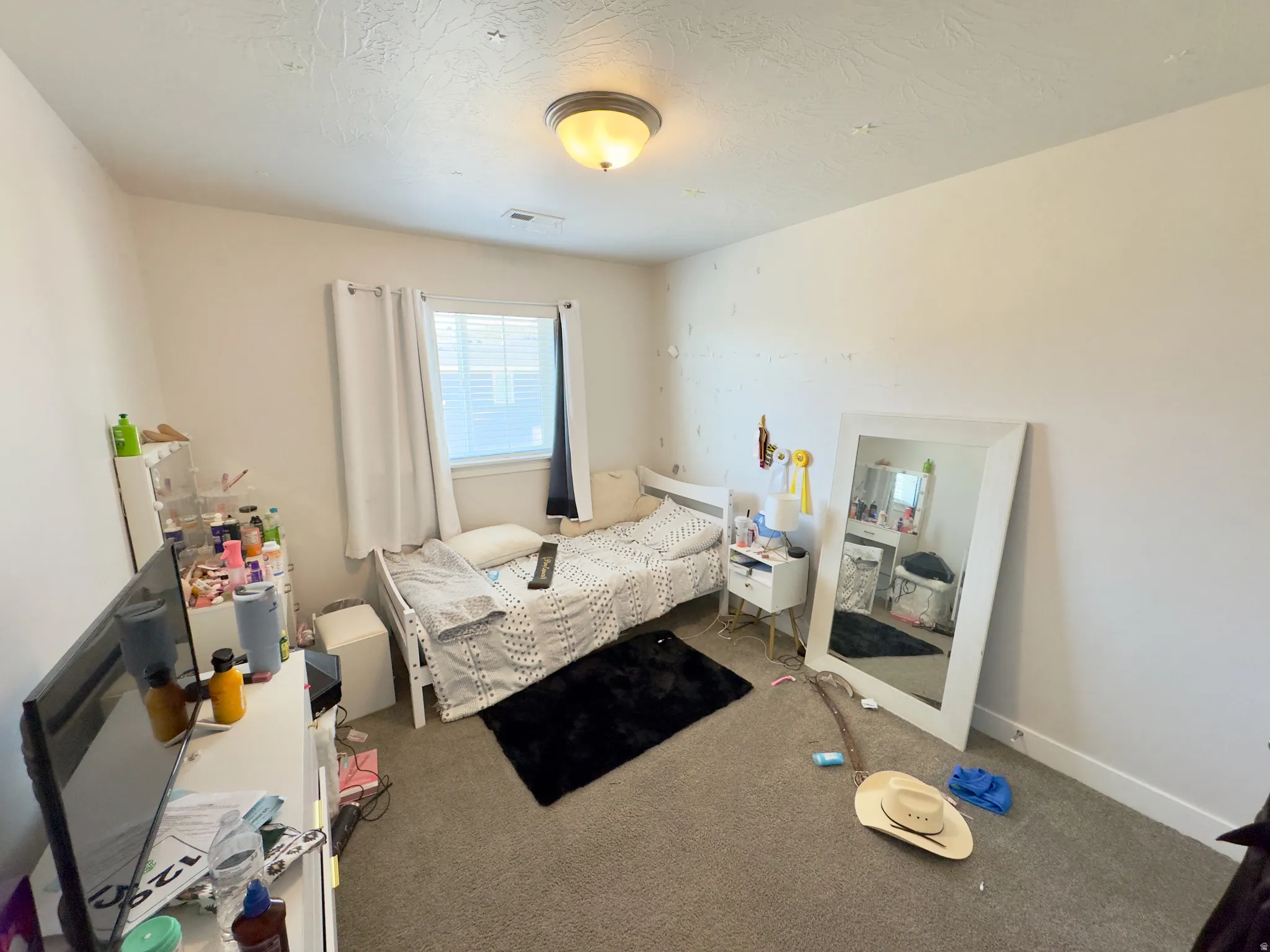 Carpeted room featuring a window with blinds, overhead flush mount lighting, and baseboard trim