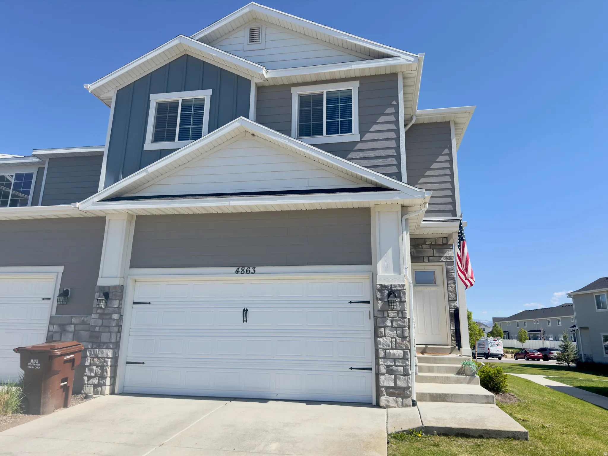 Two-story residence featuring a gray and blue exterior with white trim