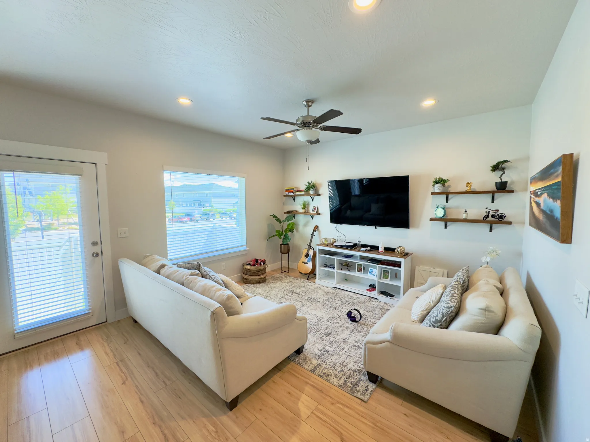 Living area featuring wood-finish flooring, recessed lighting, and a ceiling fan