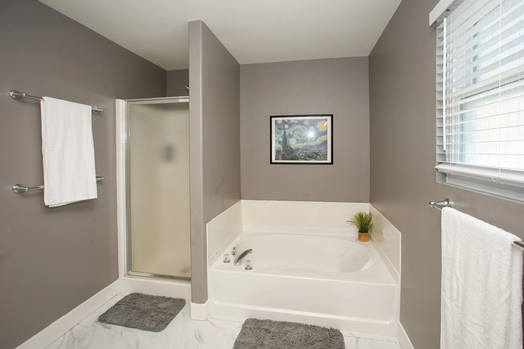 Bathroom featuring a built-in soaking tub and a glass-enclosed shower