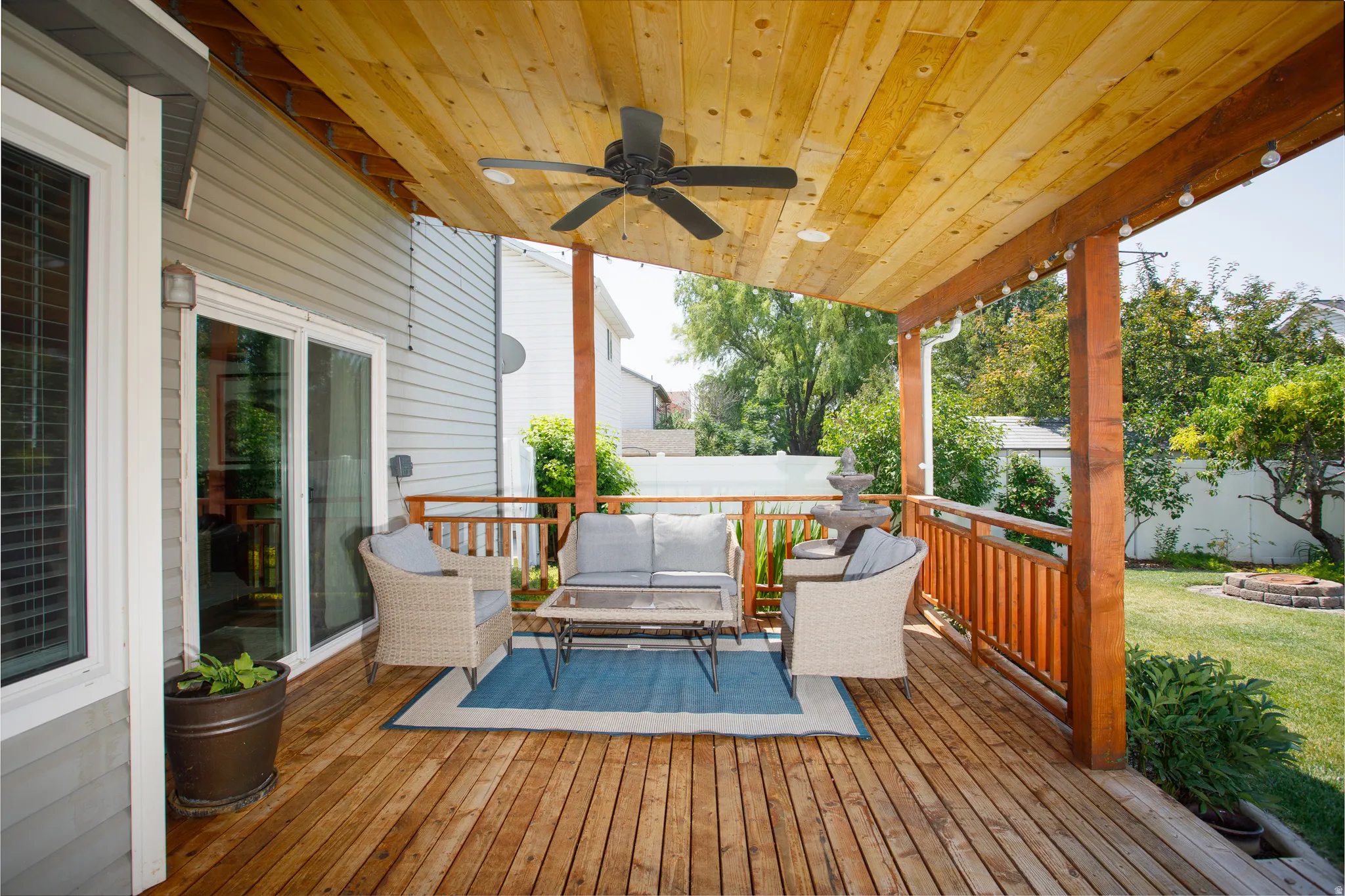 Expansive wooden deck featuring a ceiling fan, recessed lighting, and string lights