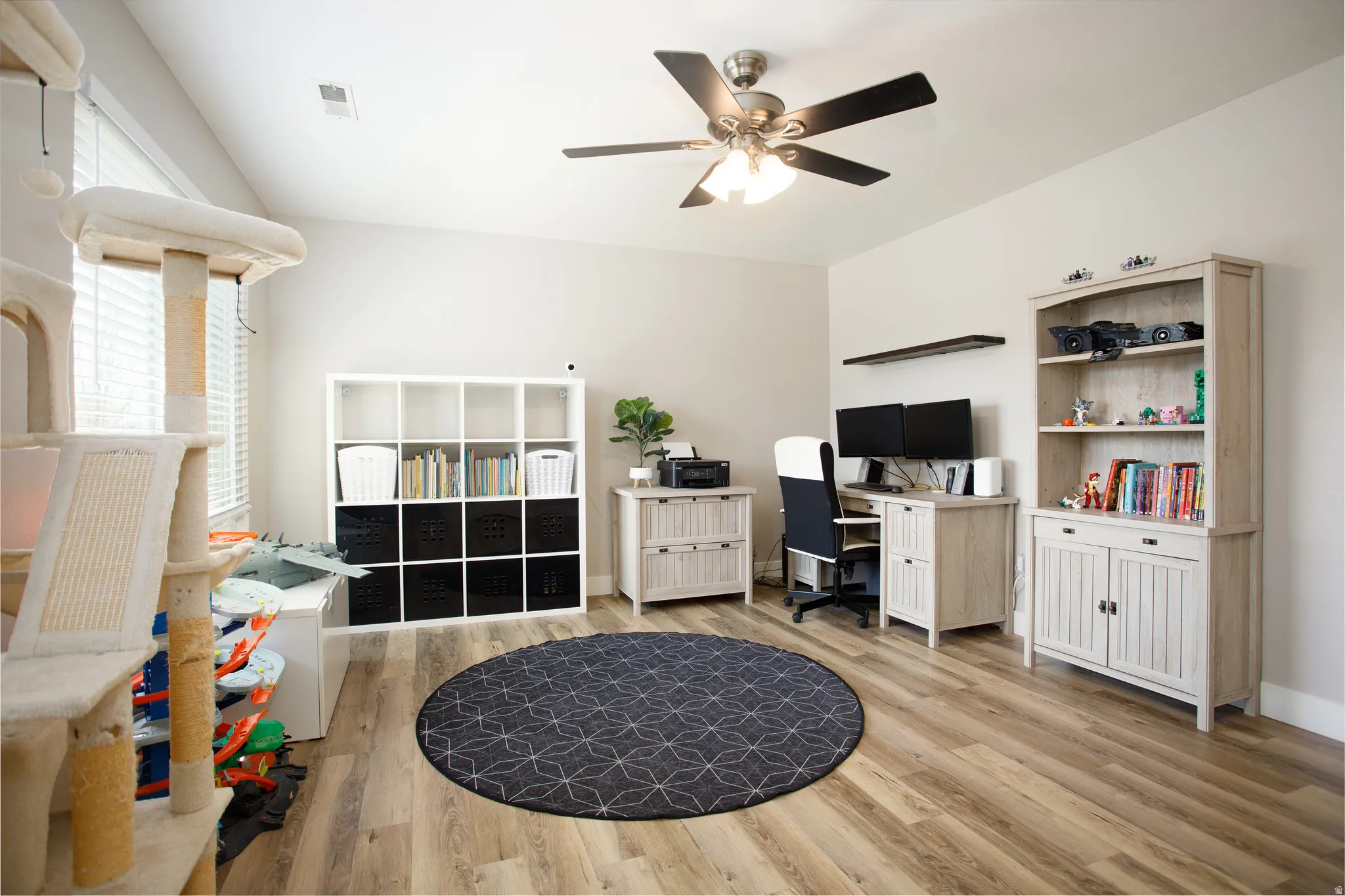Spacious room with sloped ceilings and wood-finish flooring