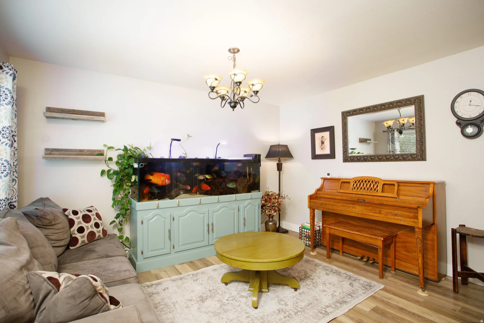 Living area featuring light wood-finish flooring, white walls, and a chandelier light fixture