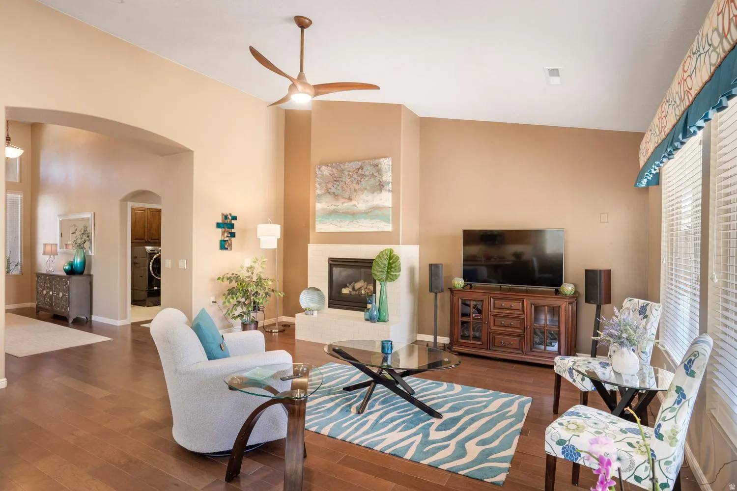 Spacious living area featuring wood-finish flooring, vaulted ceilings, and a corner fireplace