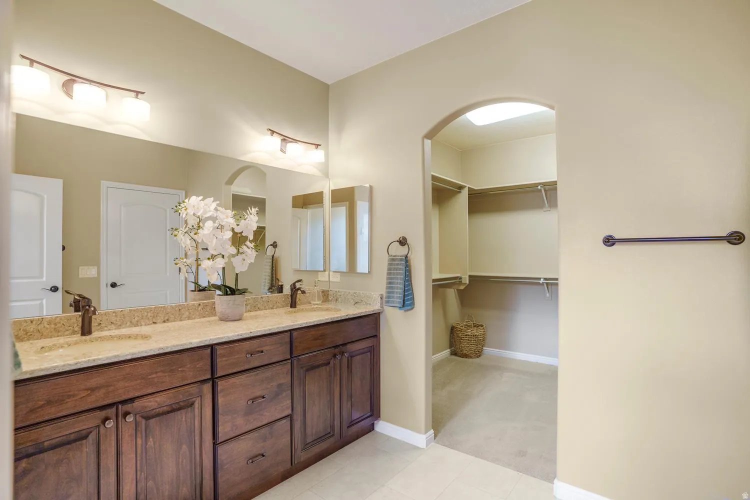 Dual vanity with undermount sinks, bronze-finish fixtures, and a spacious countertop