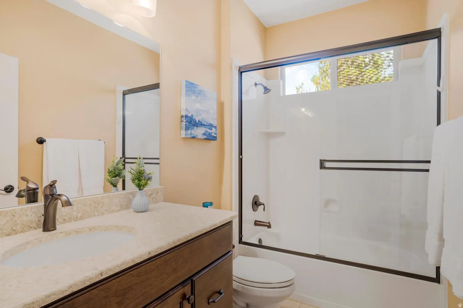 Bathroom featuring a vanity with an integrated sink, a light-toned countertop, and dark wood-finish cabinetry