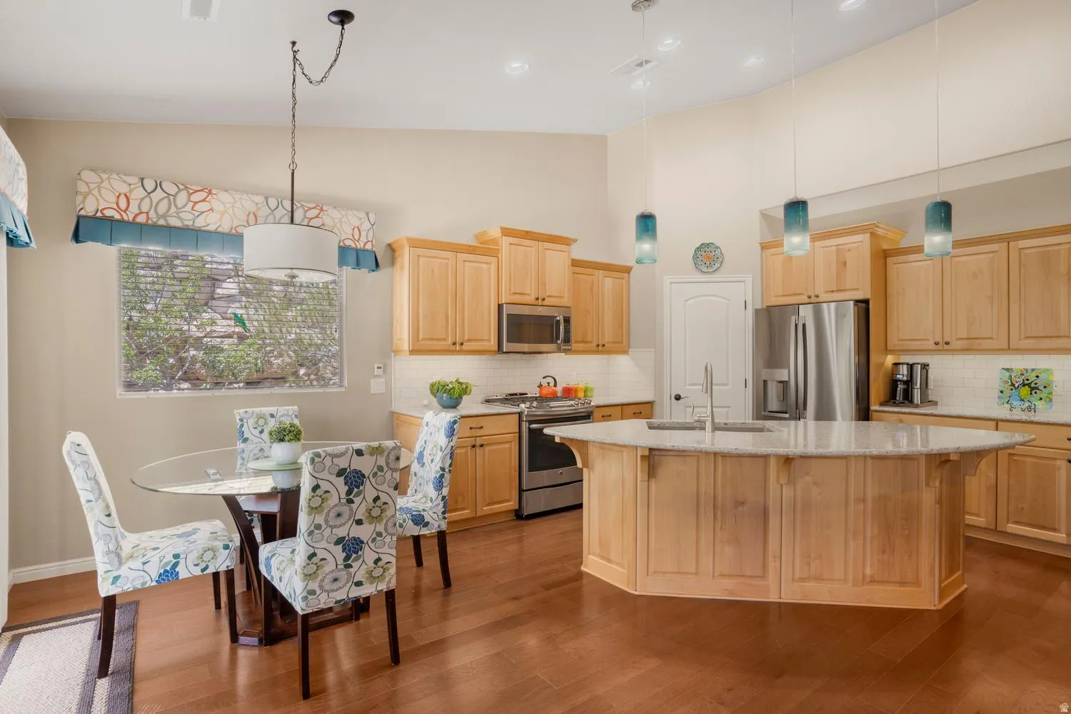 Open-concept kitchen featuring wood-finish flooring and light-toned cabinetry