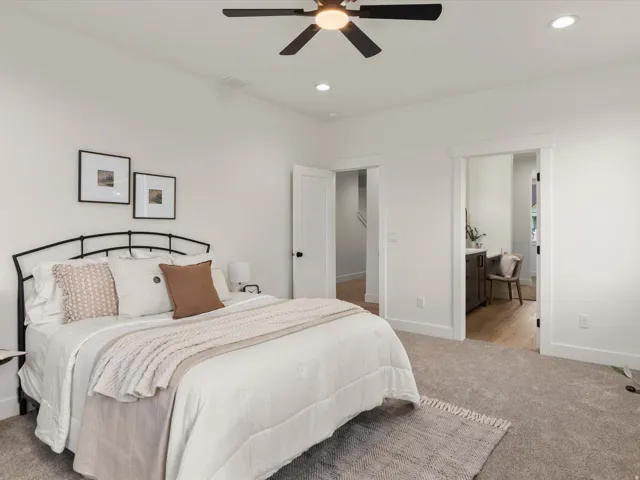 Carpeted bedroom with a ceiling fan, recessed lighting, and white walls