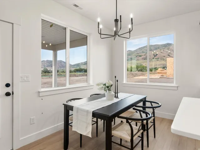 Bright dining area featuring wood-finish flooring and a contemporary black chandelier