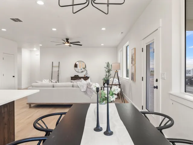 Open-concept living space featuring wood-finish flooring, recessed lighting, and a prominent ceiling fan