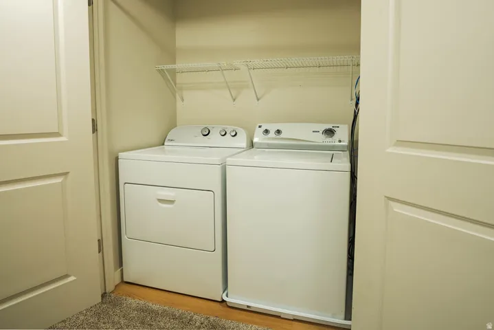 Dedicated laundry alcove featuring a white top-load washing machine and a white front-load dryer