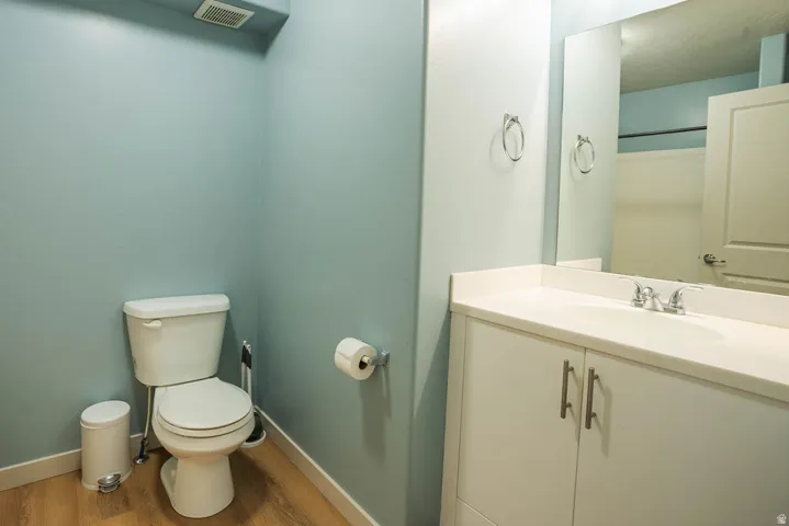 Bathroom featuring a white vanity with an integrated sink, light countertop, and a large wall-mounted mirror