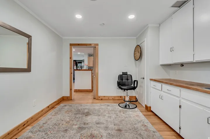 Room featuring wood-finish flooring, recessed lighting, and a doorway with natural wood trim