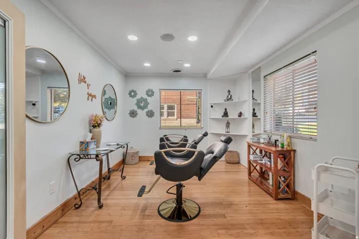 Bright interior space featuring wood-finish flooring, recessed lighting, and multiple windows with blinds