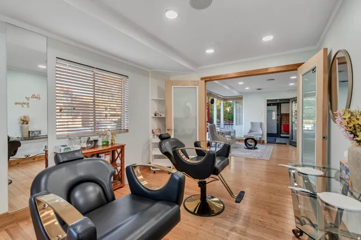 Spacious room featuring wood-finish flooring, recessed lighting, and a large window with horizontal blinds