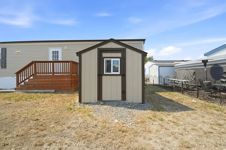Exterior storage shed featuring a single window and dual-toned siding
