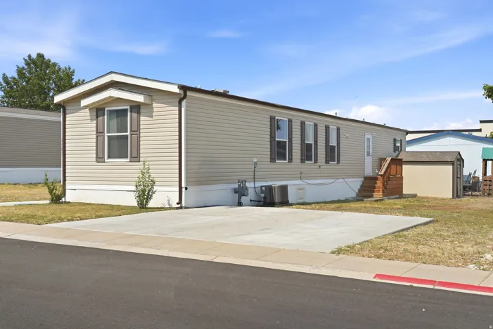 Single-story residence featuring light-colored siding and dark shutters