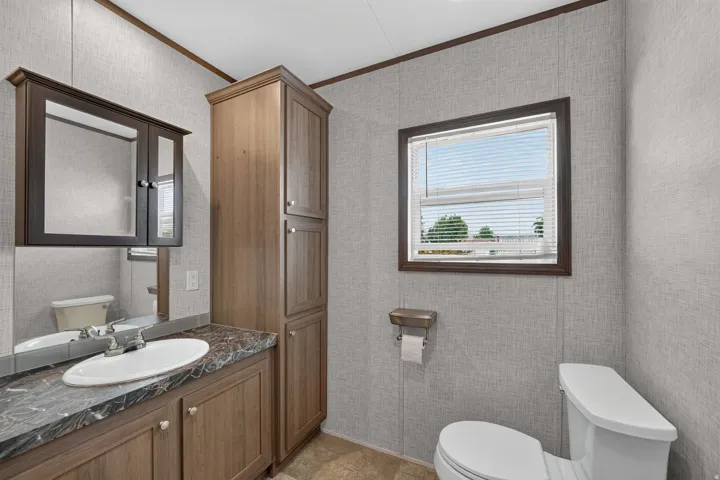 Full-size vanity with integrated sink, dark countertop, and wood-finish cabinetry