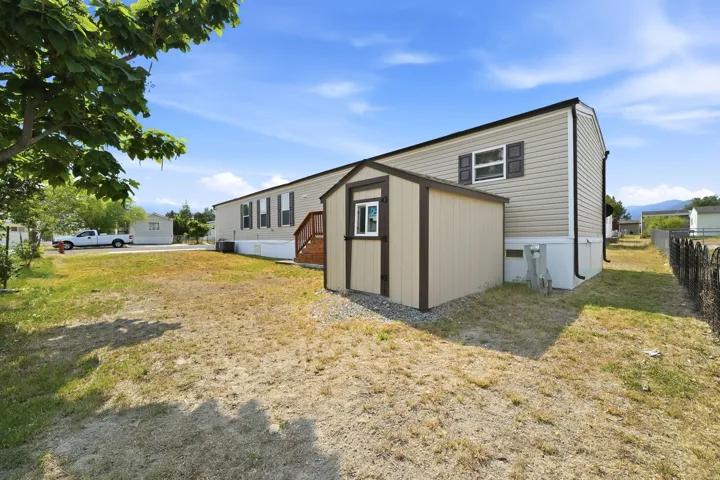 Beige siding exterior with brown window shutters