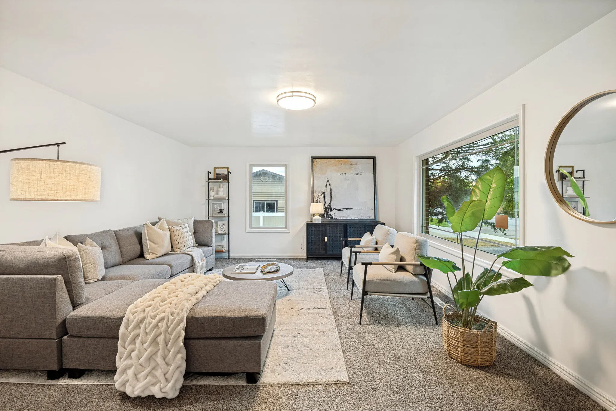Bright living space featuring white walls, a large picture window, and recessed lighting