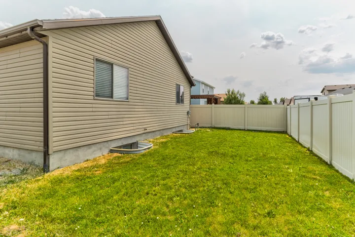 Expansive lawn bordered by a vinyl privacy fence